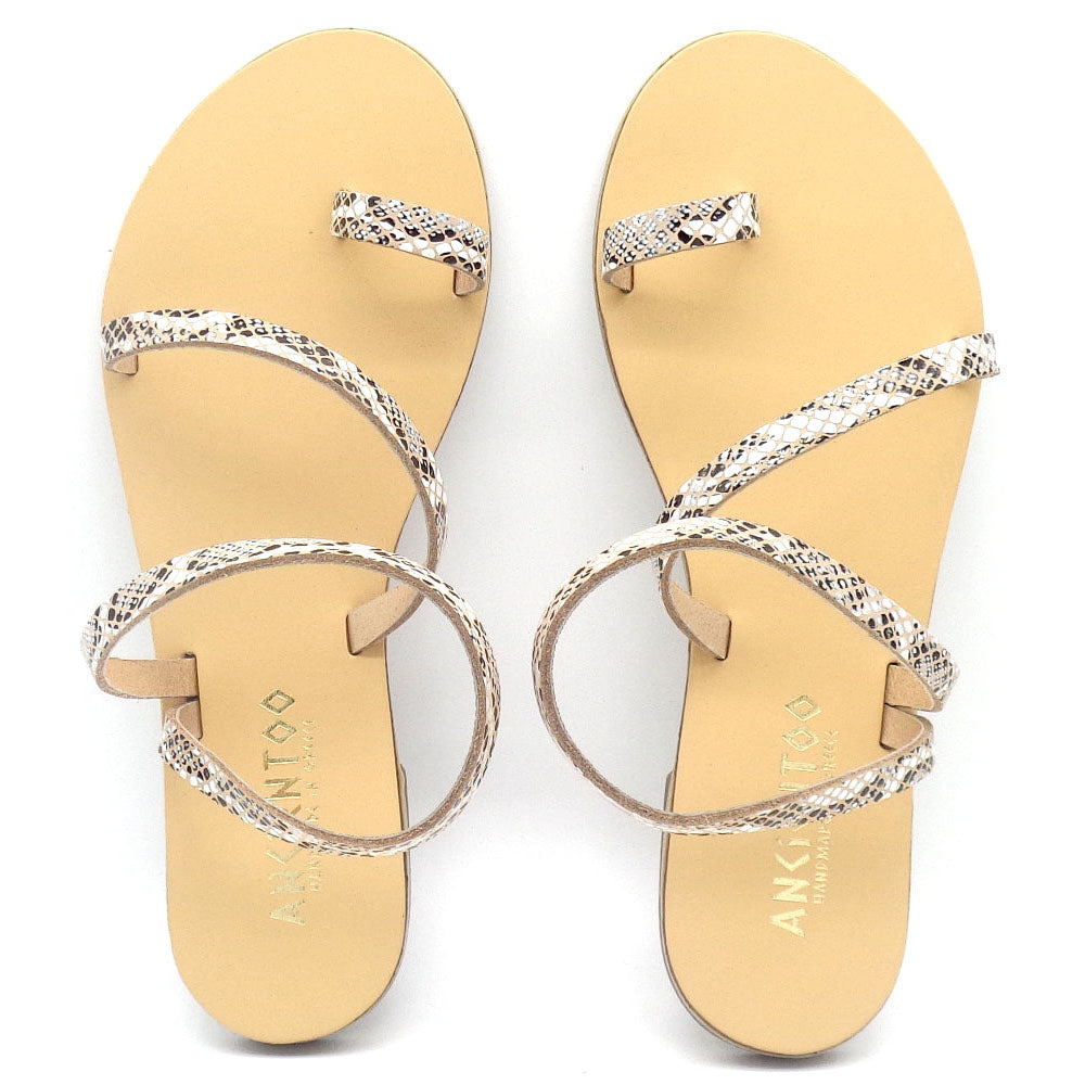Pair of yellow sandals with silver straps on a white background