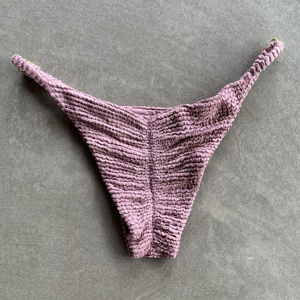 Purple textured thong on a gray background