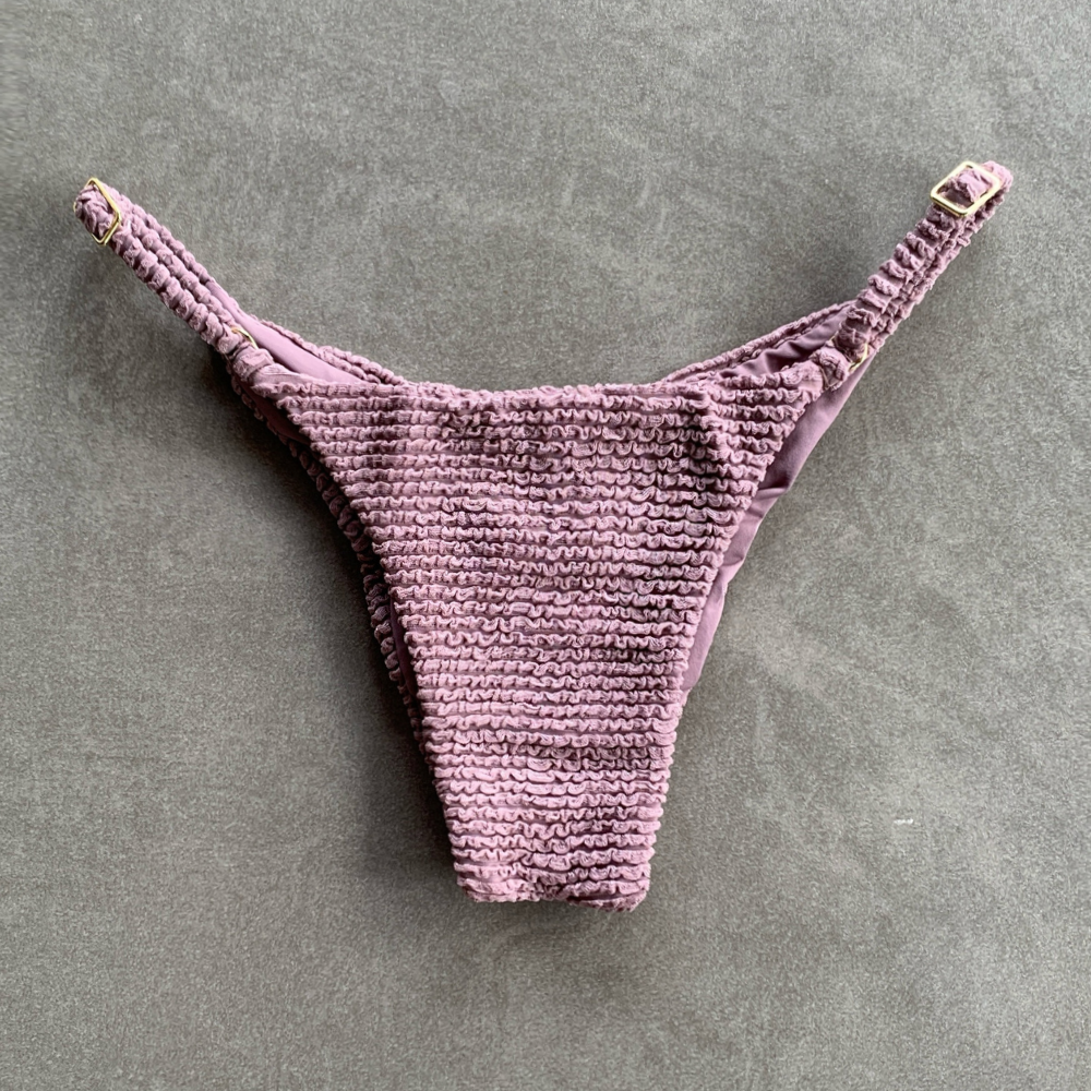 Purple textured thong on a gray background