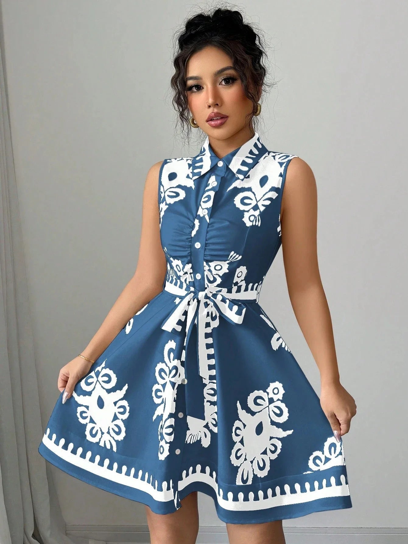 Woman wearing a blue dress with white patterns against a gray background