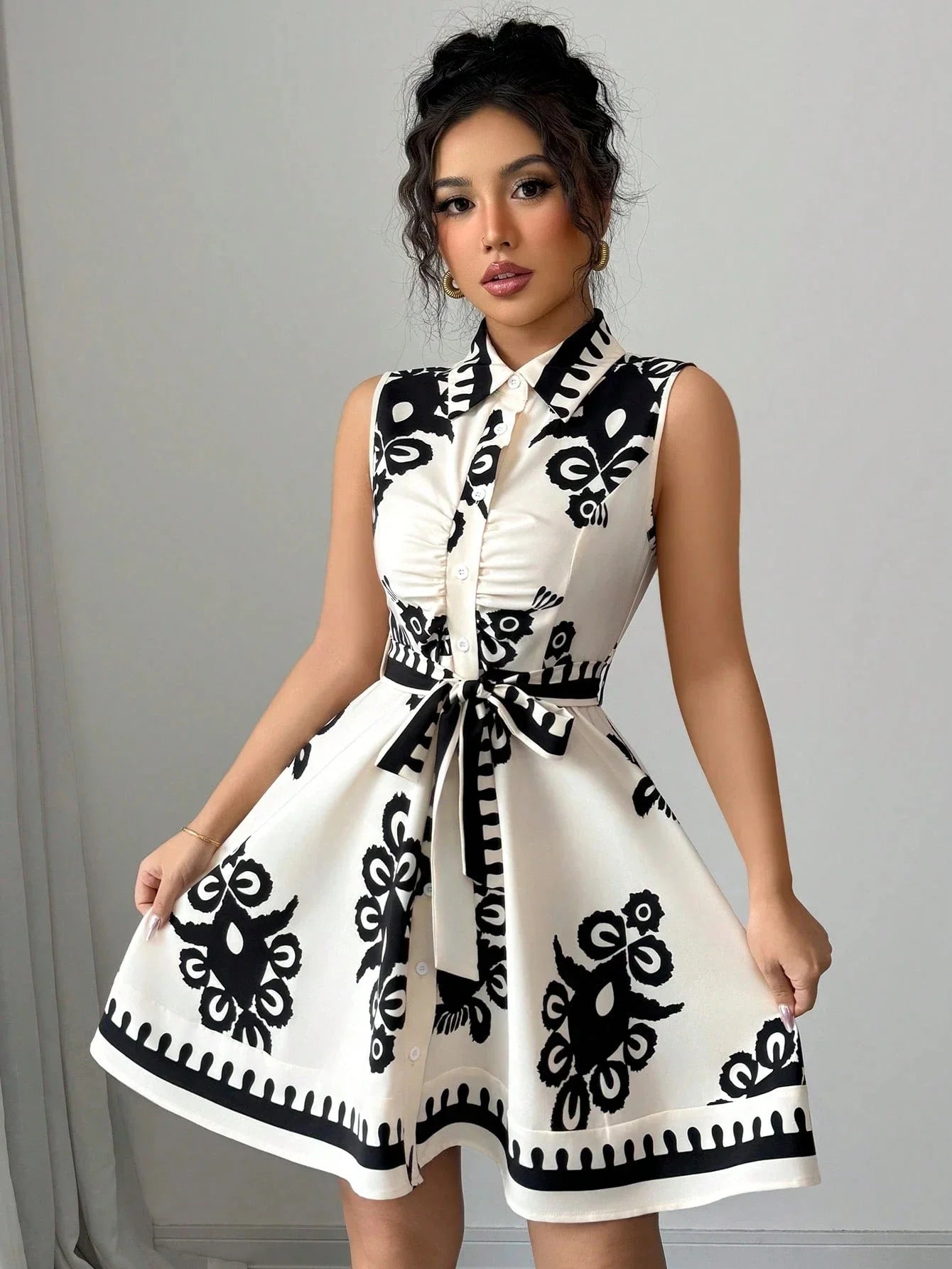 Woman wearing a black and white patterned dress against a plain background