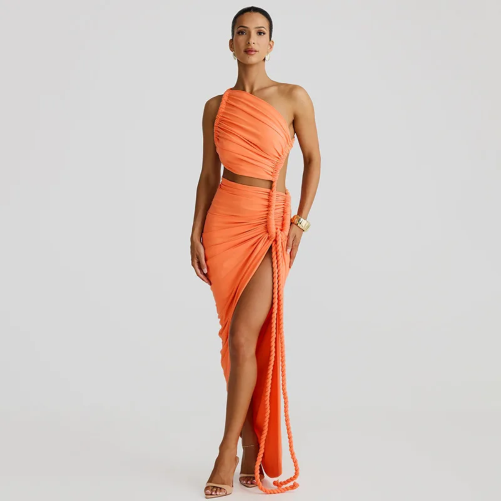 Woman wearing an orange one-shoulder dress with a slit on a light gray background