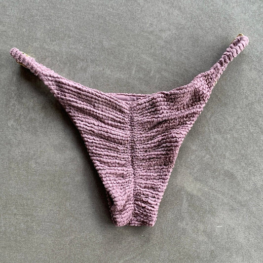 Purple textured thong on a gray background