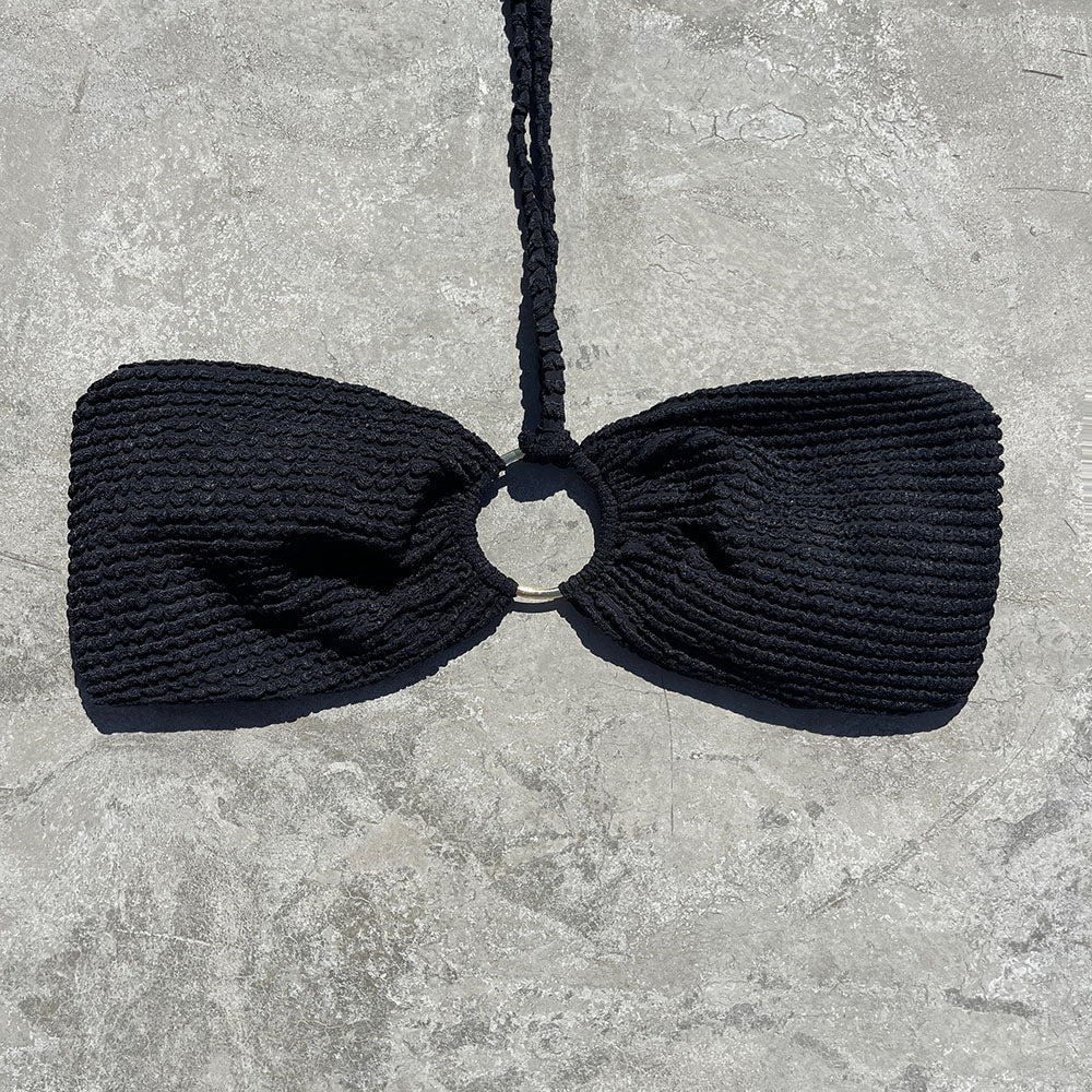 Black knitted bow tie on a gray stone surface