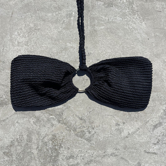 Black knitted bow tie on a gray stone surface