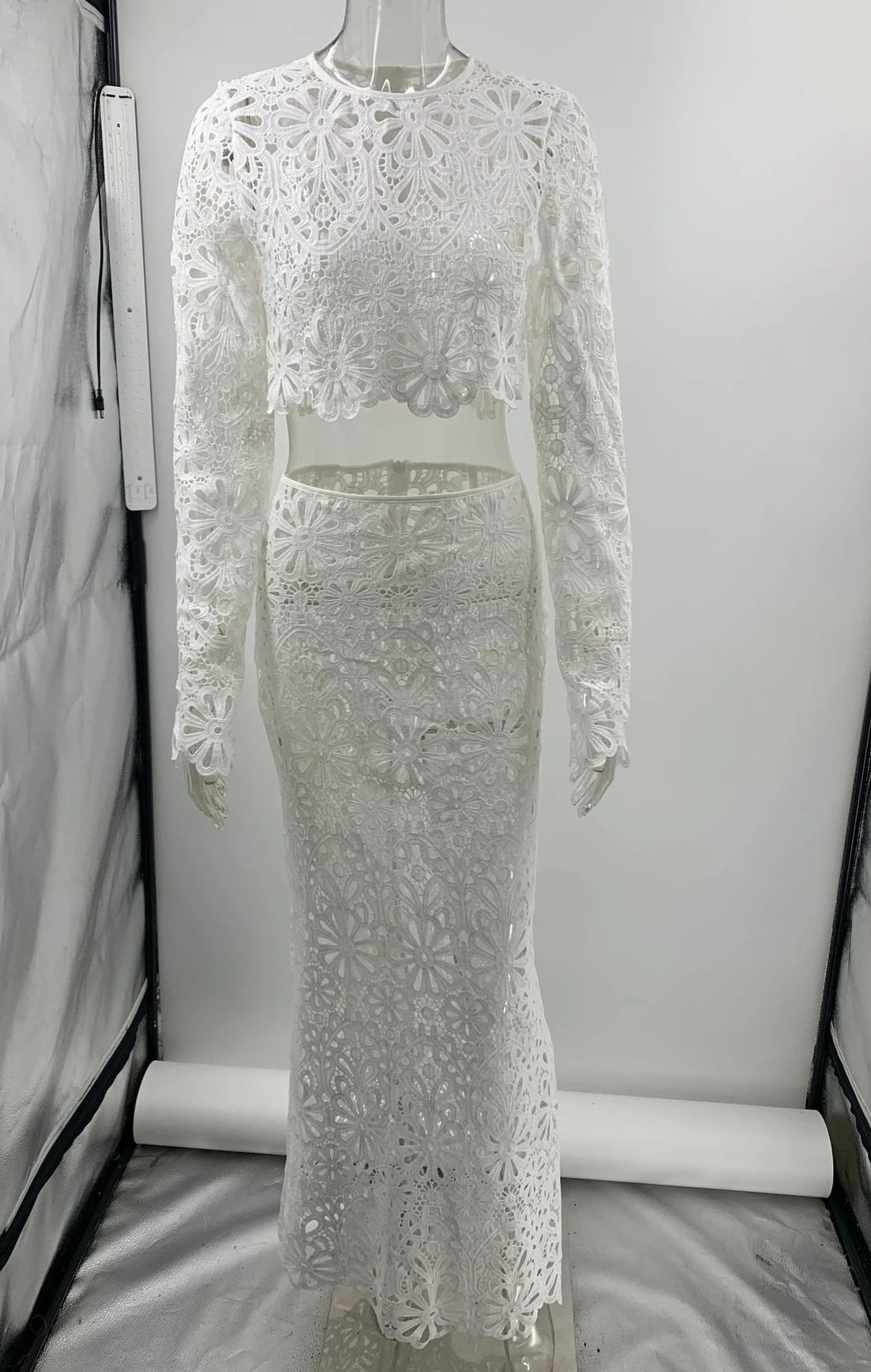 White lace two-piece outfit on a mannequin against a plain background