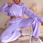 Person wearing a matching lavender hoodie and pants set sitting on a chair.