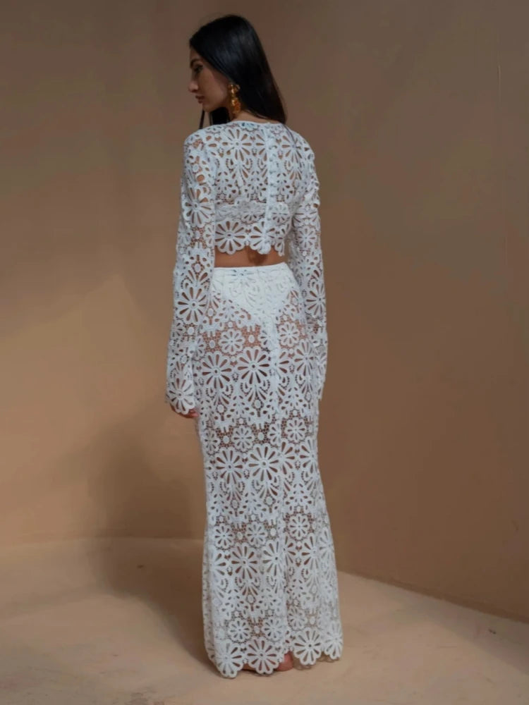 Woman wearing a white lace outfit against a beige background