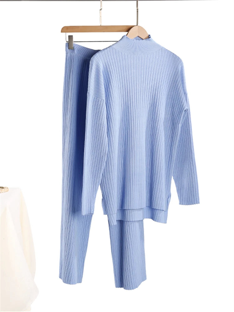 Light blue ribbed sweater and pants set on a hanger against a white background