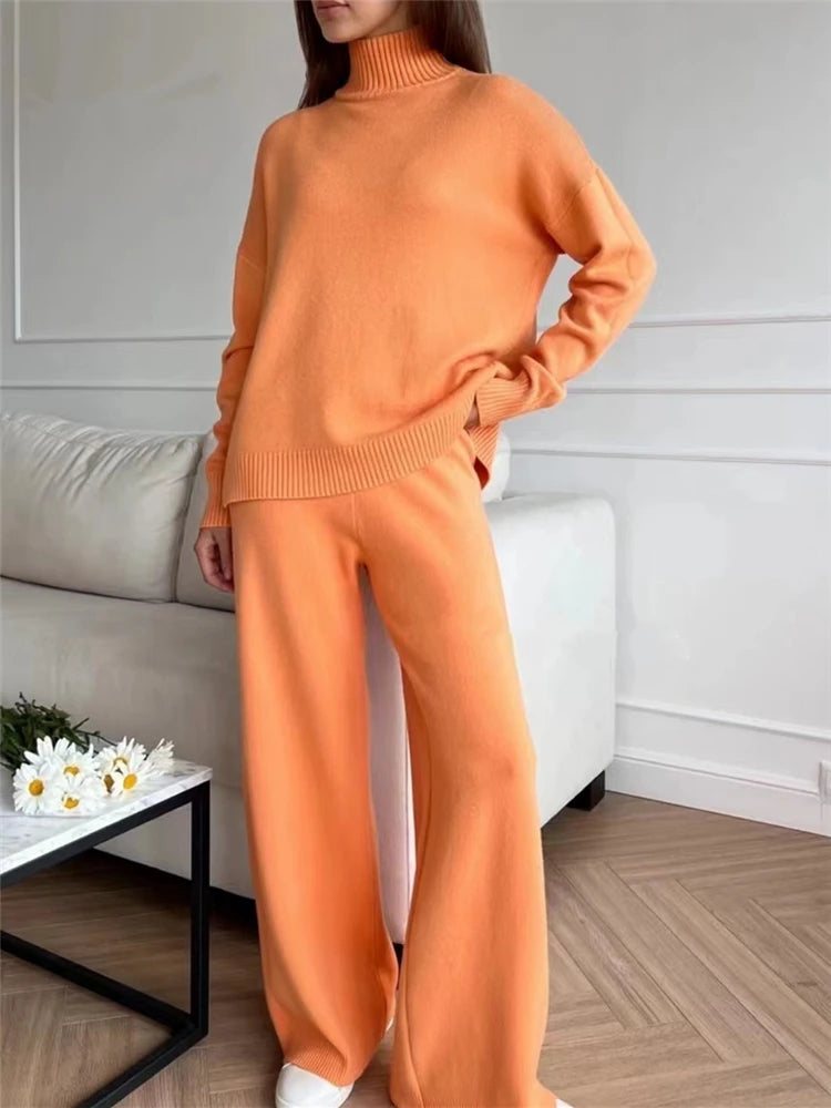 Person wearing an orange sweater and pants in a living room setting.