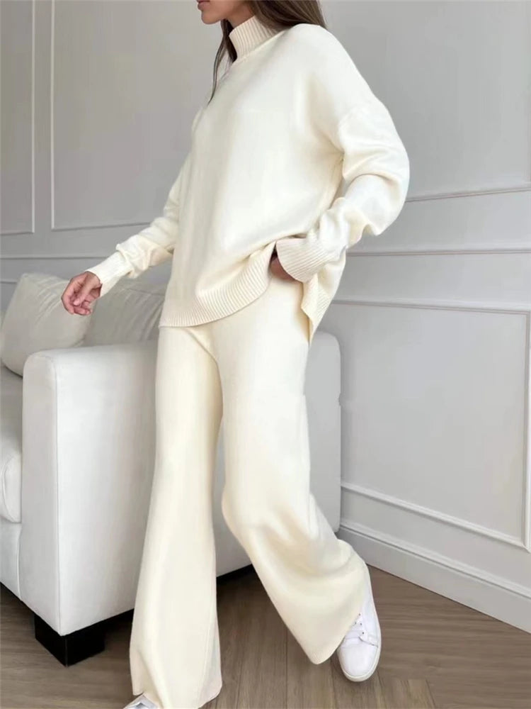 Person wearing a cream-colored outfit sitting on a white couch.