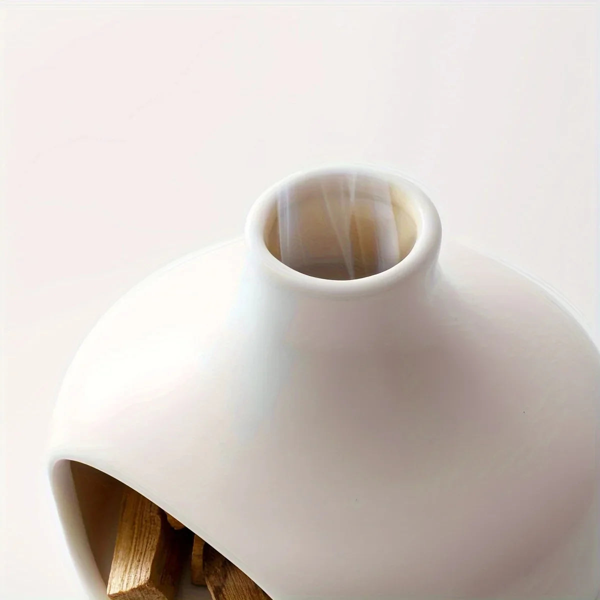 White ceramic vase with a smooth finish on a light background
