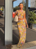 Woman in a floral outfit standing on a sidewalk