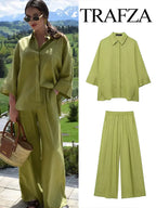 Woman wearing a green outfit with a scenic background, featuring Trafza branding.