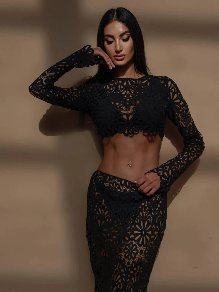 Woman wearing a black lace outfit against a neutral background