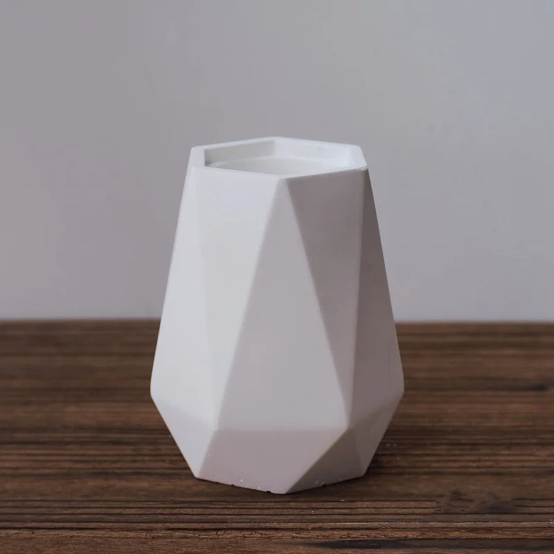 White geometric vase on a wooden surface with a plain background