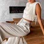 Woman sitting on a wooden stool in a modern living room with a fireplace.
