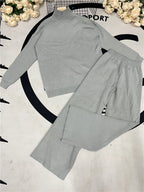 Gray outfit with long-sleeve top and pants on a white background with floral decorations.