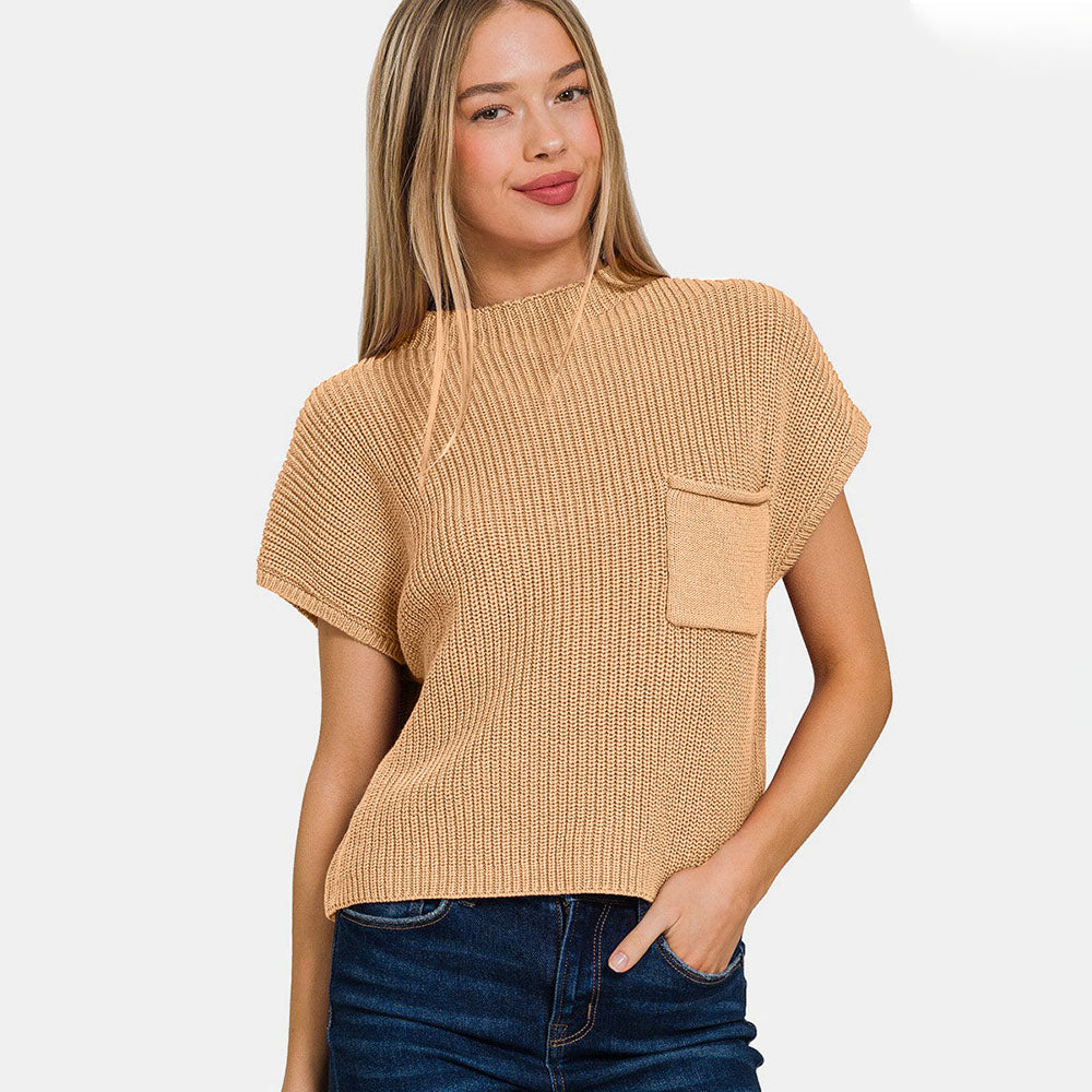 Woman wearing a beige knitted top with a pocket on a white background