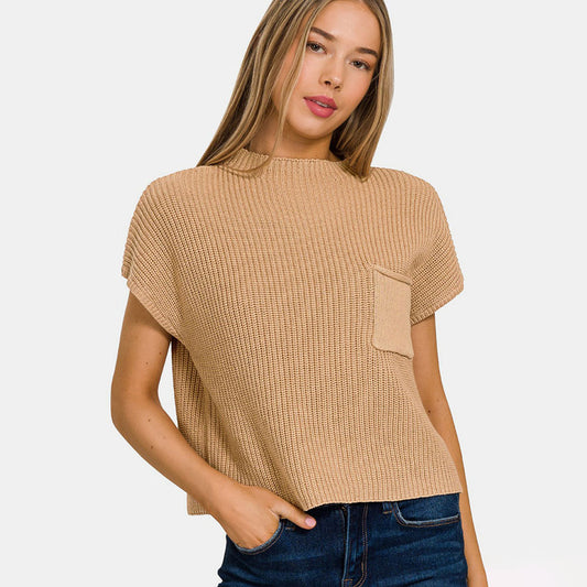 Woman wearing a beige textured top with a plain background