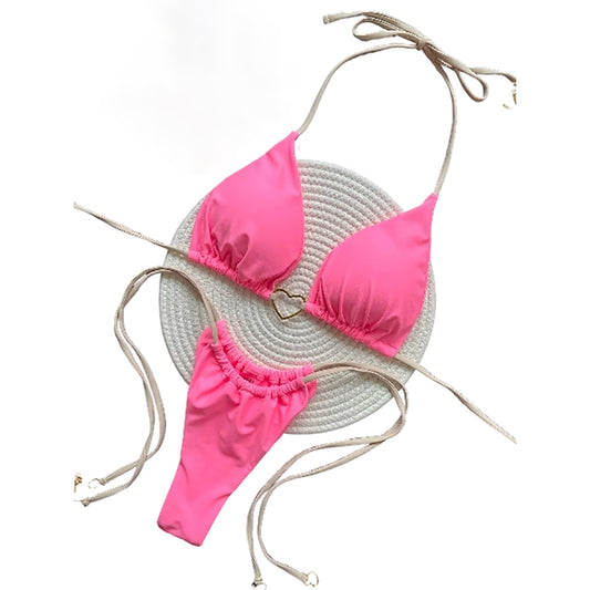 Pink bikini set with a straw hat on a white background