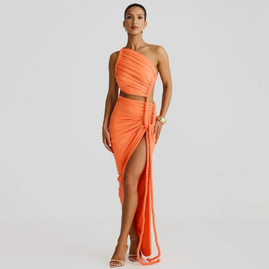 Woman wearing an orange one-shoulder dress with a slit on a light gray background