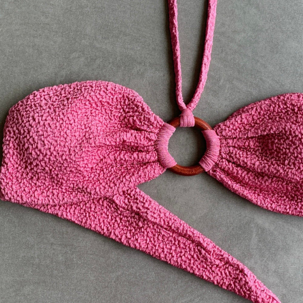 Pink textured bikini top on a gray background