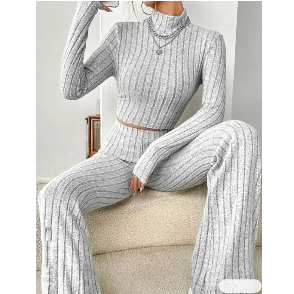Person wearing a gray ribbed knit outfit sitting on a beige couch.